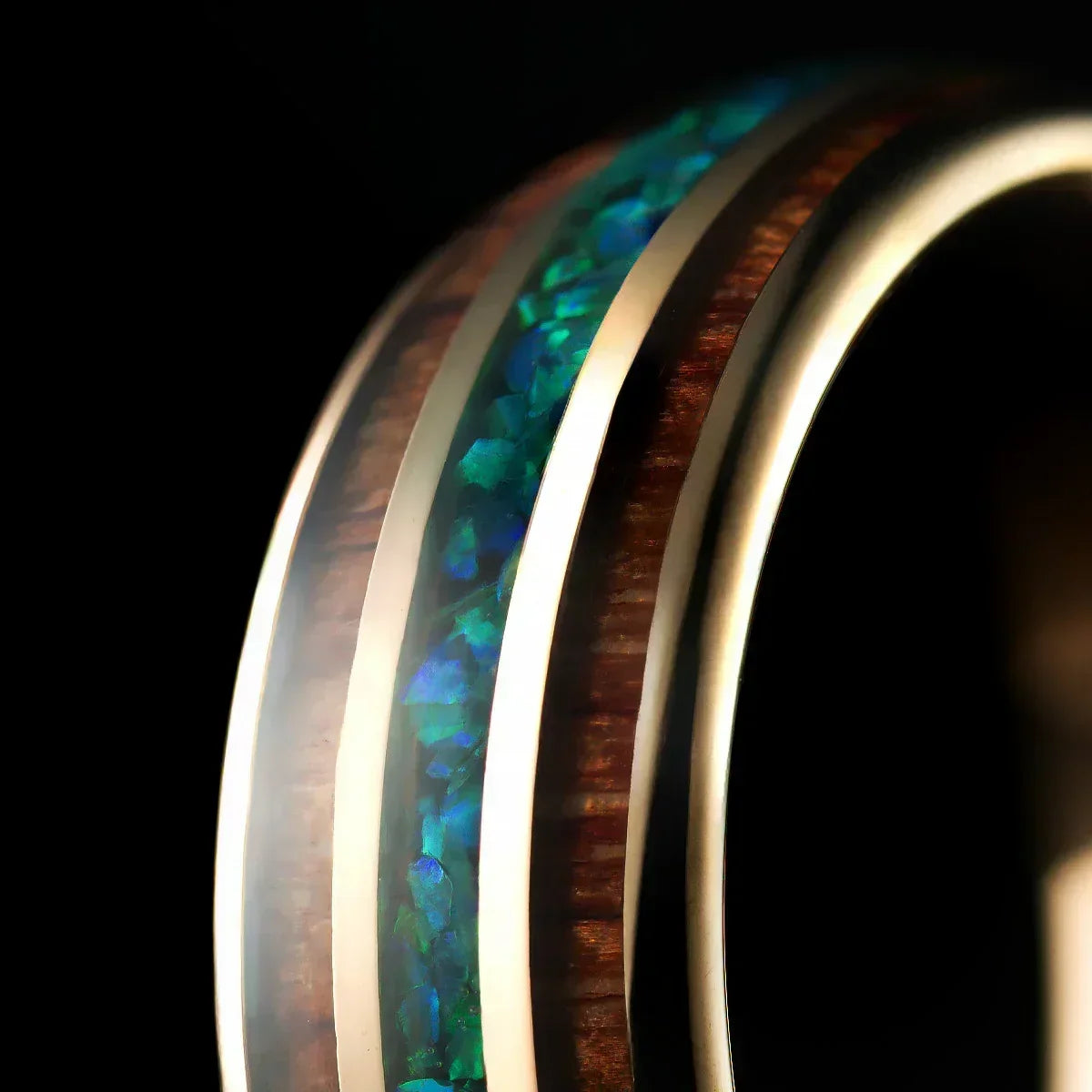 Anillo de metal dorado con incrustaciones de madera y detalles de piedras azul verdosas