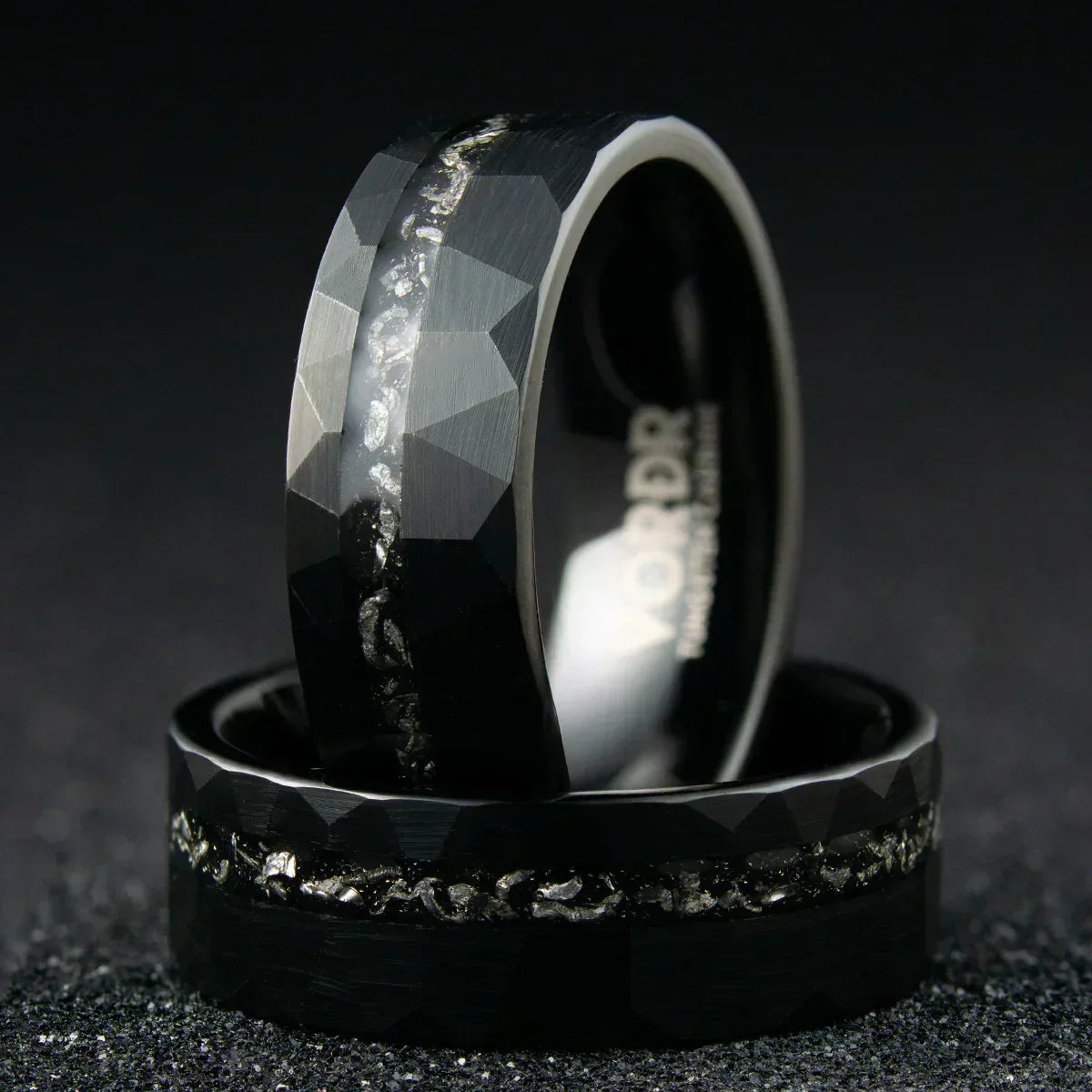Anillo negro para hombre con textura facetada y detalles de meteorito en el centro