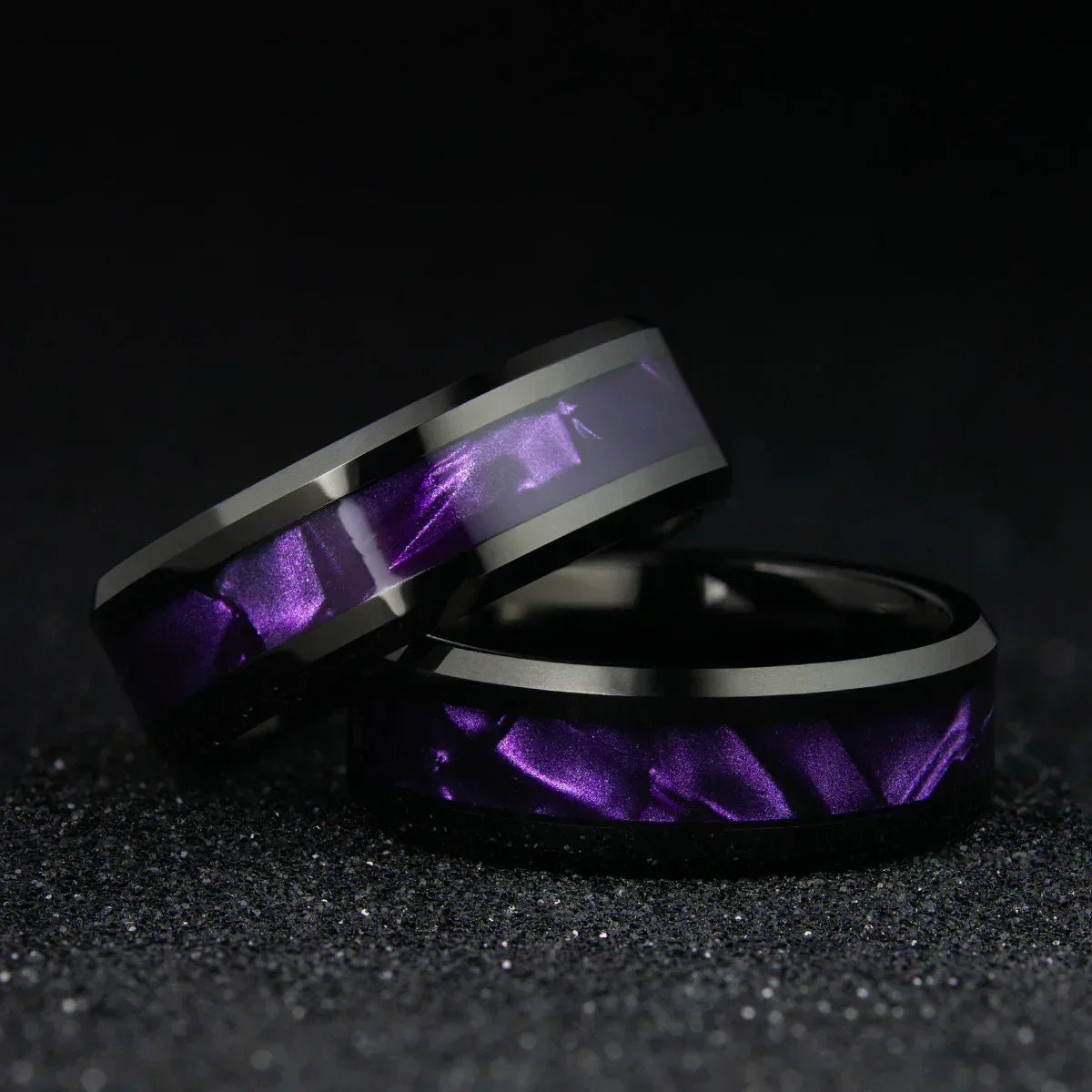 Anillos modernos de acero inoxidable con diseño morado brillante sobre fondo negro