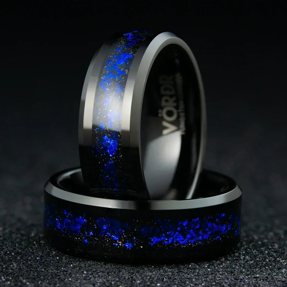 Anillo de titanio con incrustaciones azules brillantes sobre fondo negro, estilo moderno.
