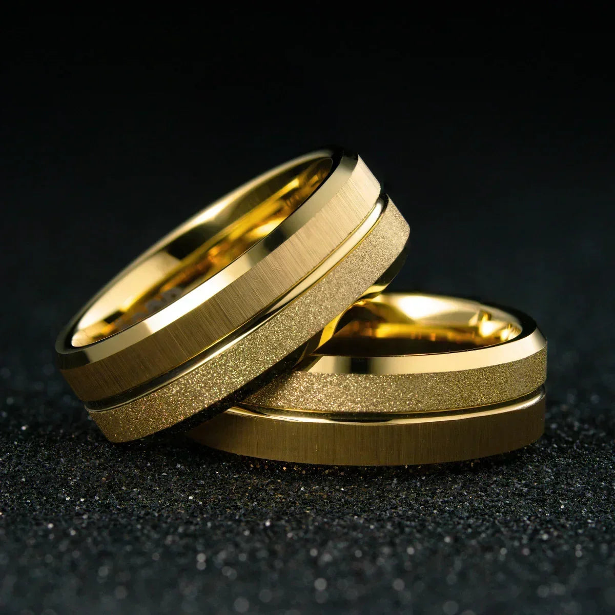 Anillos dorados de acero inoxidable con acabado mate y textura brillante, fondo negro elegante