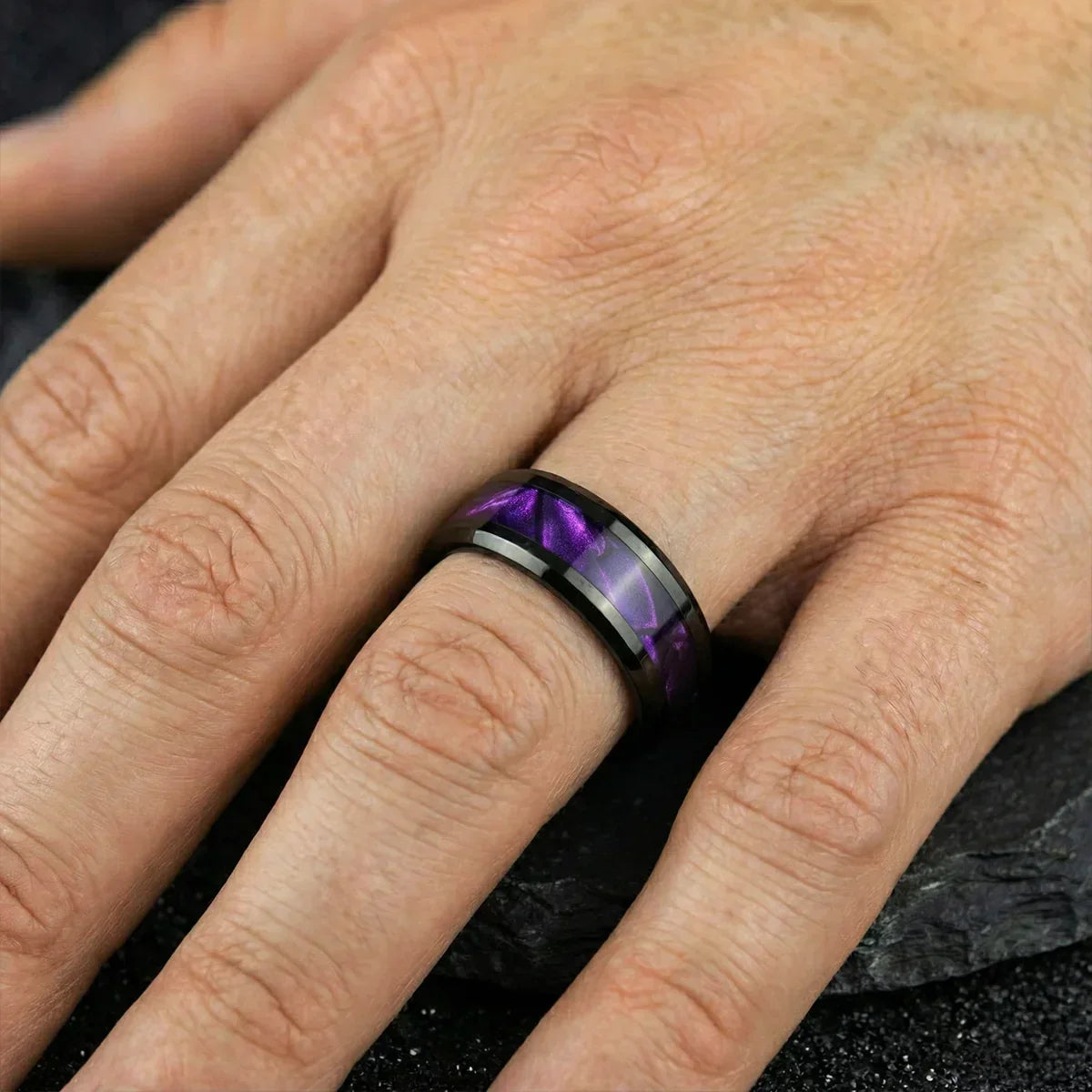 Anillo de acero inoxidable con incrustación morada, diseño moderno en mano masculina