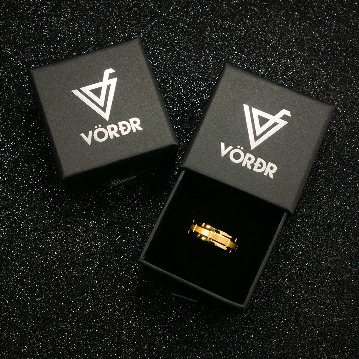 Anillo dorado de lujo en caja negra de joyería sobre fondo brillante