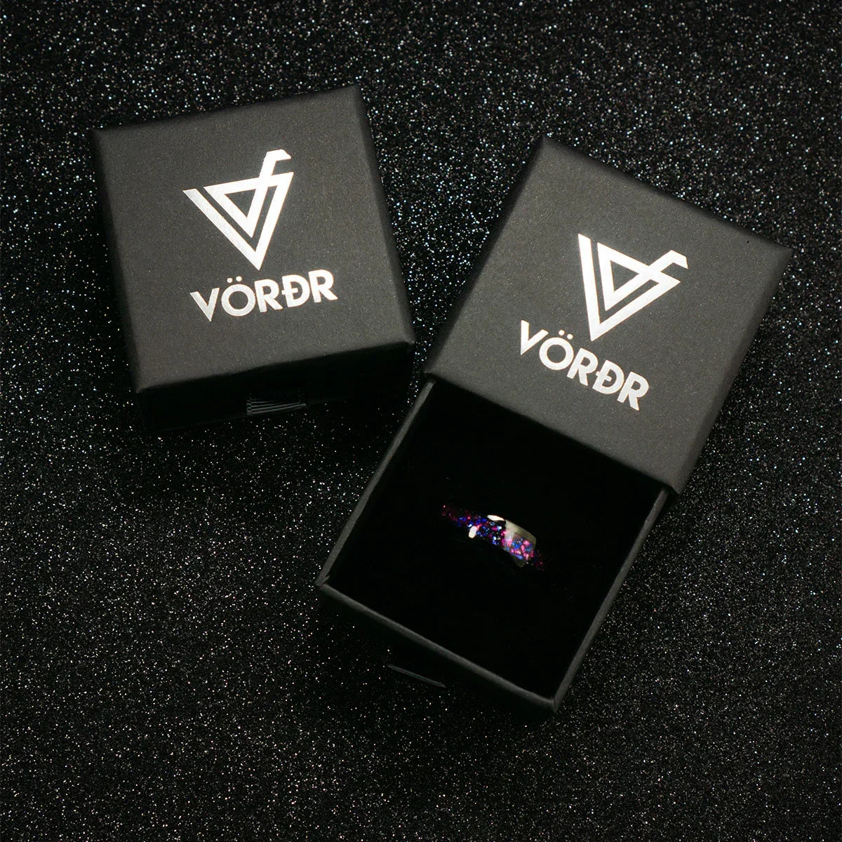 Anillo de acero con detalles en tonos morados y azules en caja negra elegante