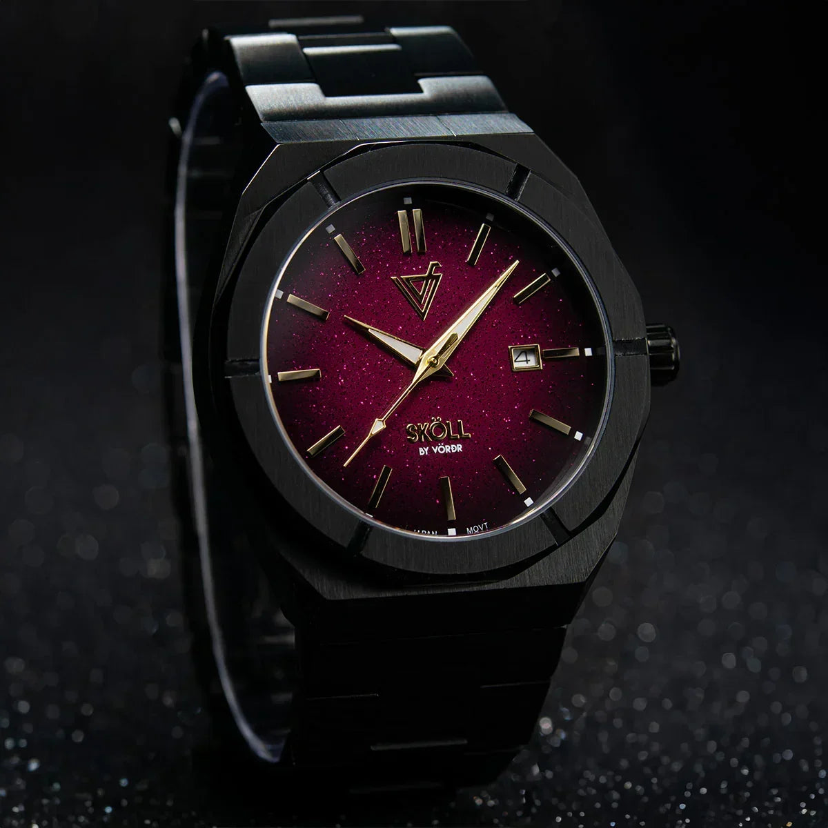 Reloj elegante de pulsera con caja negra y esfera roja, índices dorados y fecha.