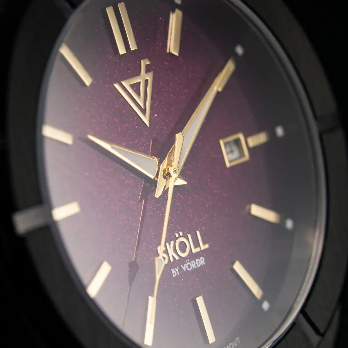 Primer plano de reloj elegante con carátula púrpura y detalles dorados, diseño moderno