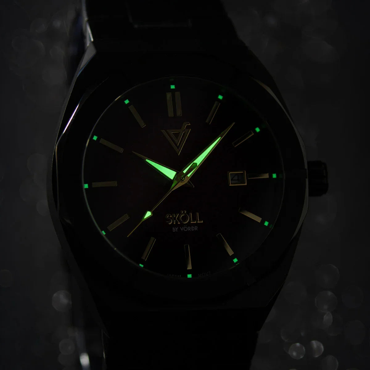 Reloj elegante negro con manecillas y marcadores luminosos verdes en la oscuridad