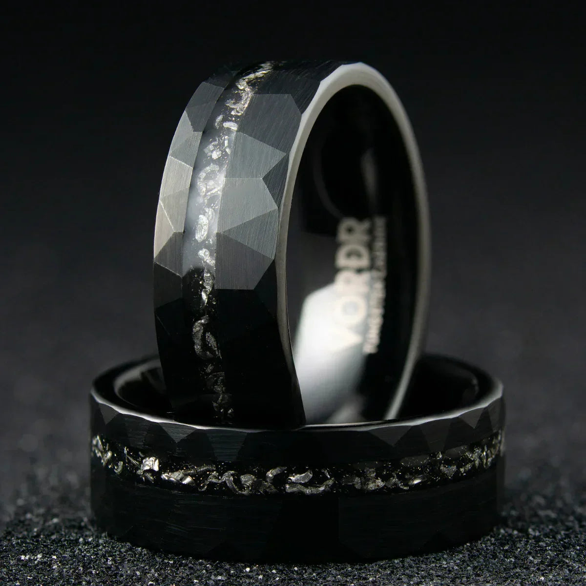 Anillo negro para hombre con textura facetada y detalles de meteorito en el centro