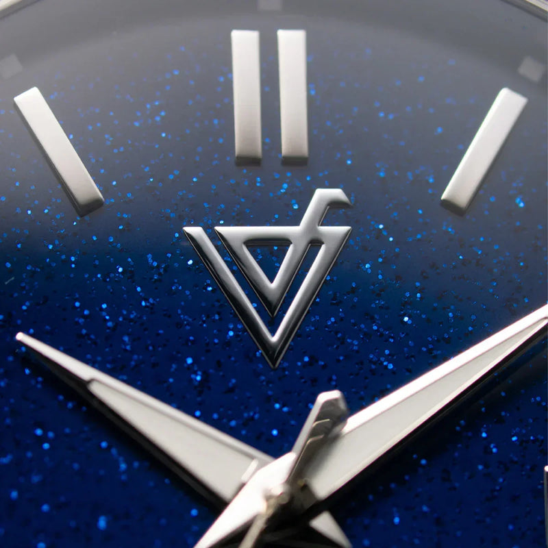 Primer plano de esfera de reloj azul con destellos y manecillas plateadas elegantes